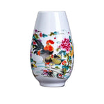Vase décoratif en porcelaine blanche avec motif de fleurs colorées et de coqs ornementaux.