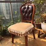 Une chaise vintage élégante avec un dossier sculpté et un coussin rembourré recouvert d'un joli napperon en dentelle, dans un cadre verdoyant près d'une fenêtre.