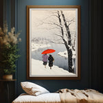 Deux personnes marchent ensemble sous un parapluie rouge dans un paysage enneigé hivernal, avec des arbres dénudés en arrière-plan.