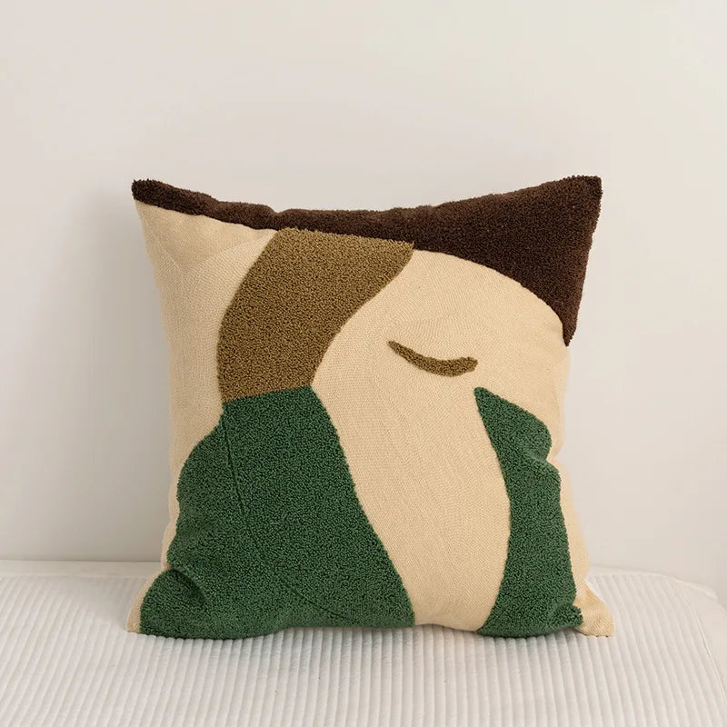 Coussin ornemental de style contemporain avec des formes géométriques en beige, vert et brun.