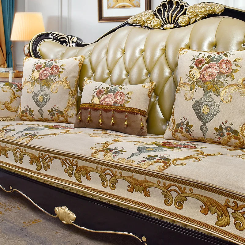 Ce sofa de luxe en velours doré est orné de motifs floraux colorés et de détails dorés sophistiqués, créant une ambiance élégante et raffinée.