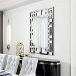 Élégant miroir à facettes dans une salle à manger moderne avec un éclairage d'ambiance et des chaises capitonnées.