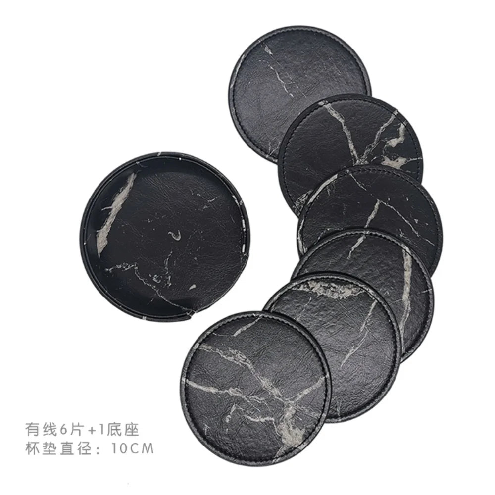 Des dessous-de-plat ronds en pierre noire avec des veines blanches, idéaux pour protéger les surfaces des tables.