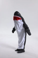 Un costume en peluche représentant un requin menaçant avec de grandes dents rouges et des yeux noirs effrayants.