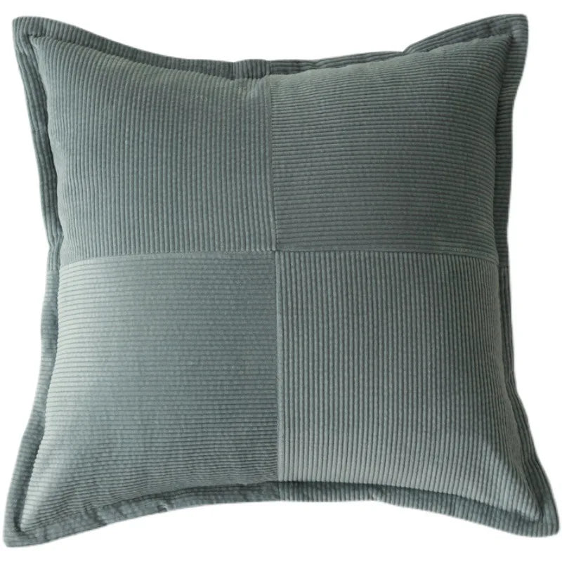 Coussin décoratif gris à motifs côtelés, créant une ambiance confortable et élégante dans l'espace.