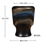 Un vase en céramique rectangulaire avec des motifs de paysage abstraits en dégradés de bleu et de brun.