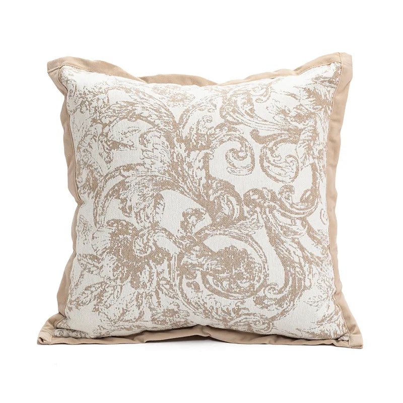 Coussin décoratif de style vintage avec un motif floral élégant et subtil sur un fond clair.