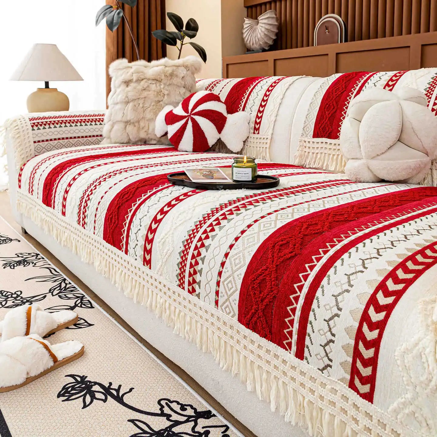 Couvre-lit décoratif aux motifs ethniques rouges et blancs, avec des oreillers moelleux et une plateau sur le côté, dans une pièce meublée avec goût.