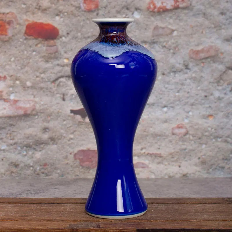 Ce vase en céramique présente une texture craquelée et une couleur bleu éclatant, créant une pièce décorative élégante et unique.