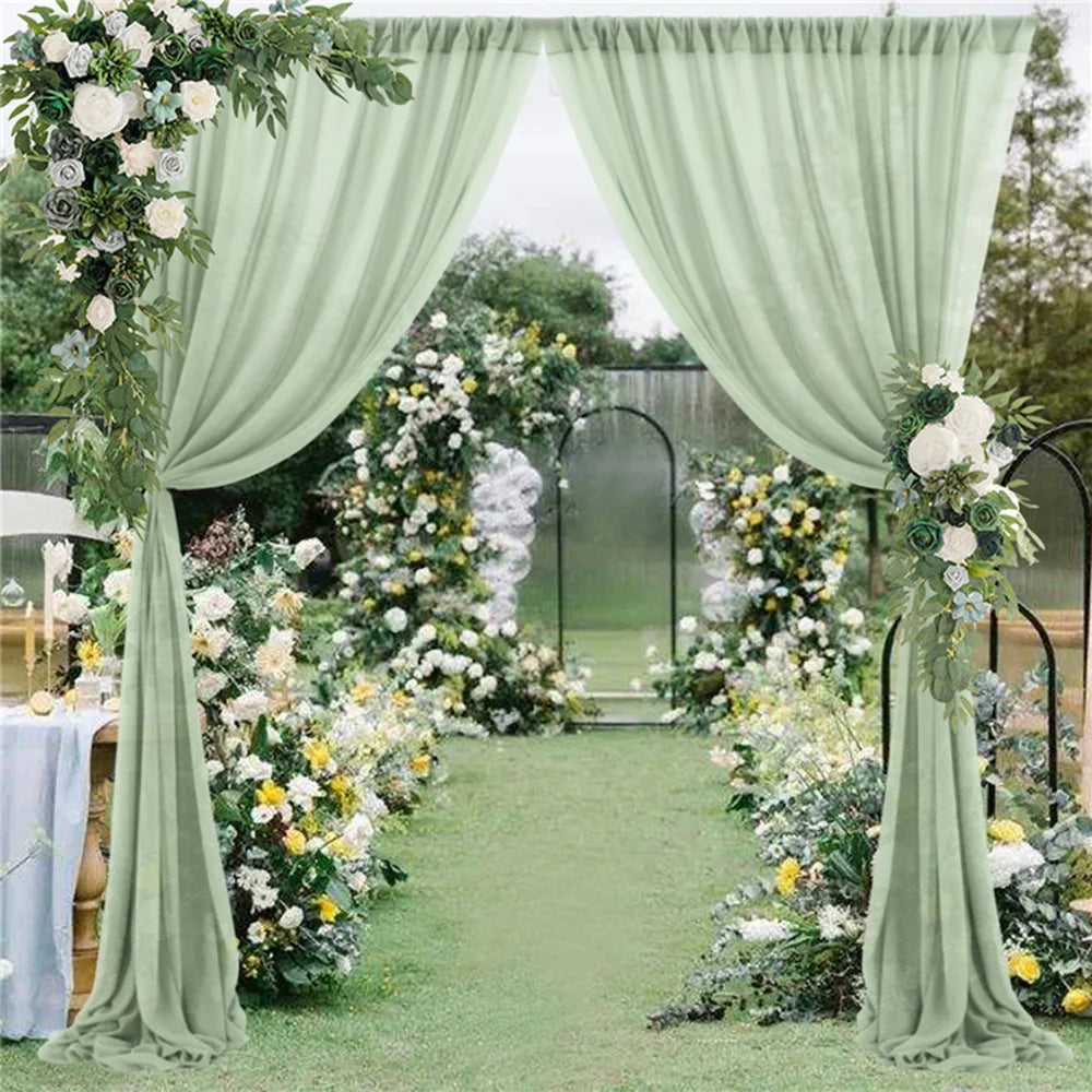 Décor de mariage idyllique avec un chemin fleuri encadré de rideaux verts et d'une arche fleurie en arrière-plan, créant une atmosphère bucolique et romantique.