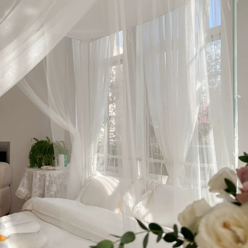 Une chambre à coucher douillette et lumineuse avec des rideaux blancs flottants qui donnent une ambiance paisible et raffinée.