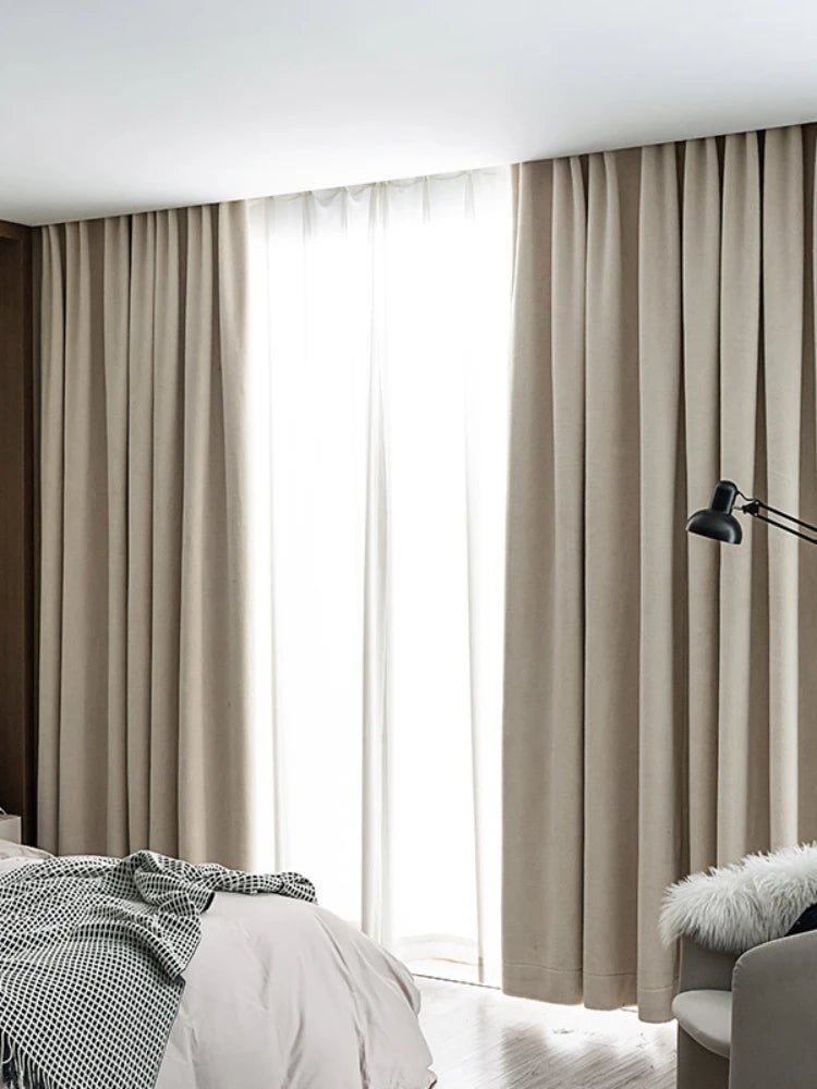 Rideaux opaques dans une chambre moderne, offrant une ambiance chaleureuse et élégante avec une lumière douce filtrant à travers les plis. Ensemble avec un lit confortable, ces rideaux créent un espace de repos apaisant. Idéal pour une décoration intérieure chic et contemporaine.