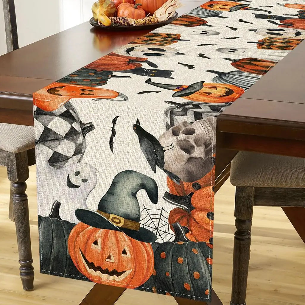 Nappe de table décorée d'éléments d'Halloween, tels que des citrouilles, un chapeau de sorcière et des oiseaux noirs, créant une ambiance festive et propice à la célébration de cette période de l'année.