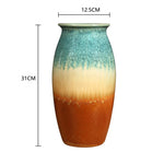 Vase artisanal en céramique aux couleurs émeraude et ocre, avec des dimensions de 31 cm de hauteur et 12,5 cm de diamètre.