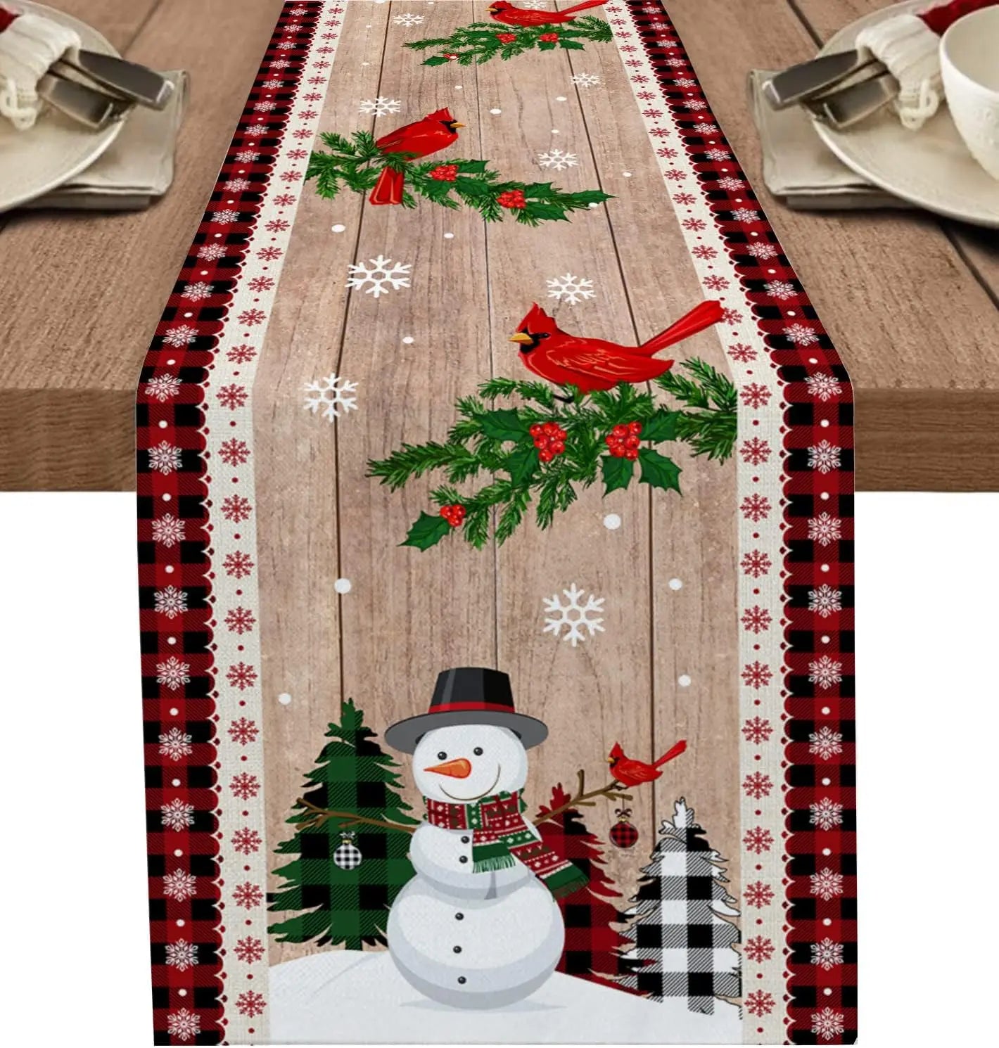 Une nappe de table de Noël avec des décorations festives telles que des cardinaux rouges, des branchages de sapin et un bonhomme de neige.