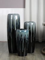 Ensemble de vases décoratifs en céramique noire et bleu-vert avec un design distinctif aux coulures et textures irrégulières, donnant un aspect unique et artistique.