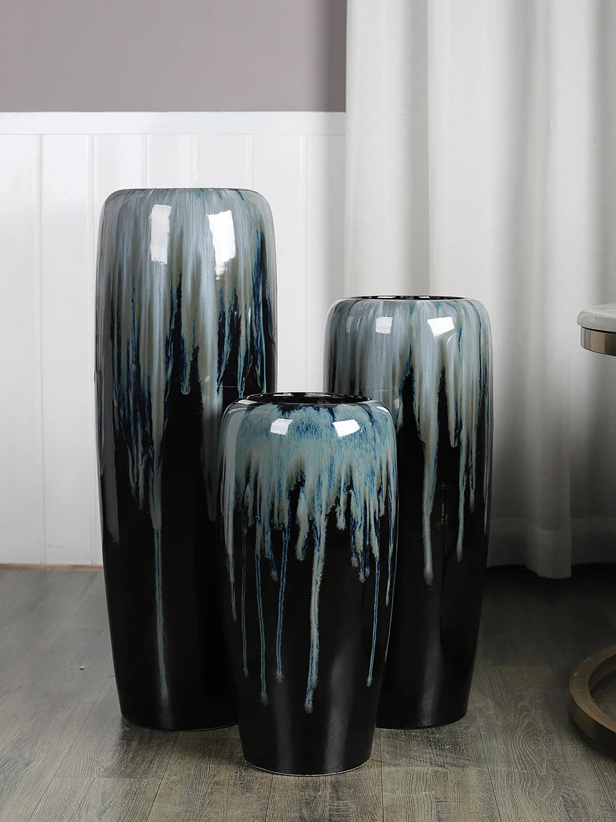 Ensemble de vases décoratifs en céramique noire et bleu-vert avec un design distinctif aux coulures et textures irrégulières, donnant un aspect unique et artistique.