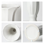 Carafe blanche en céramique avec couvercle en verre, goulot effilé et détails circulaires sur le corps, présentant une forme élégante et un design épuré.