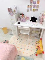 Un bureau blanc lumineux et organisé, avec un ordinateur, des accessoires et de jolies décorations aux couleurs pastel, créant une ambiance chaleureuse et accueillante.