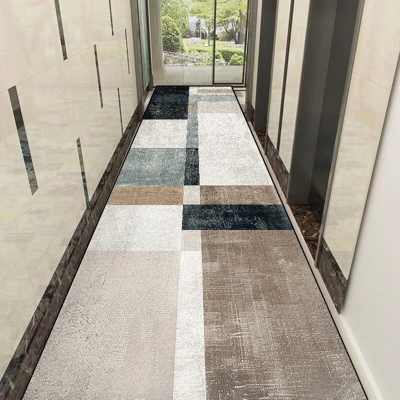 Le couloir est recouvert d'un carrelage mosaïque gris, beige et noir, offrant un design géométrique élégant et harmonieux.