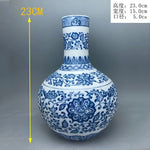 Un élégant vase décoratif en porcelaine bleu et blanc, orné de motifs floraux et de végétation stylisés, représentant la beauté de l'artisanat traditionnel chinois.