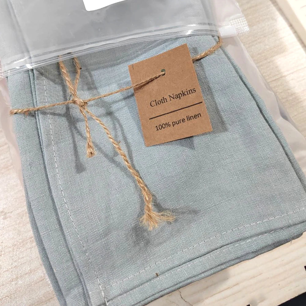 Serviettes en lin pur de couleur grise sous emballage transparent, avec une étiquette indiquant qu'il s'agit de serviettes en lin 100% pur.