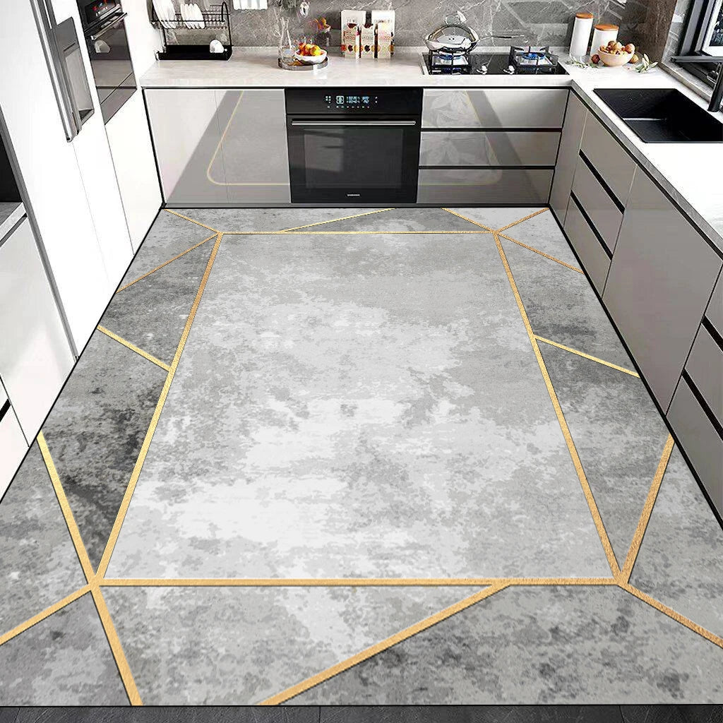 Un carrelage gris marbré aux motifs géométriques dorés apporte une touche de design moderne à cette cuisine élégante.