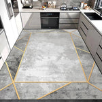 Un carrelage gris marbré aux motifs géométriques dorés apporte une touche de design moderne à cette cuisine élégante.