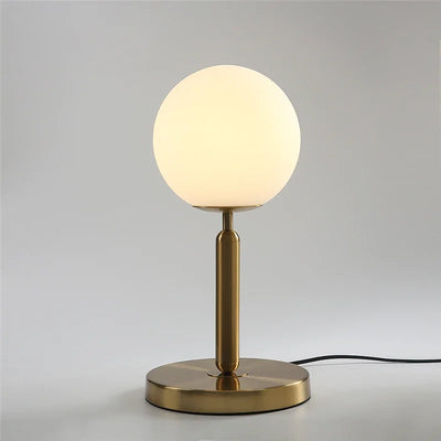 Lampe de chevet design boule de verre laiteuse LED blanche sur table de nuit