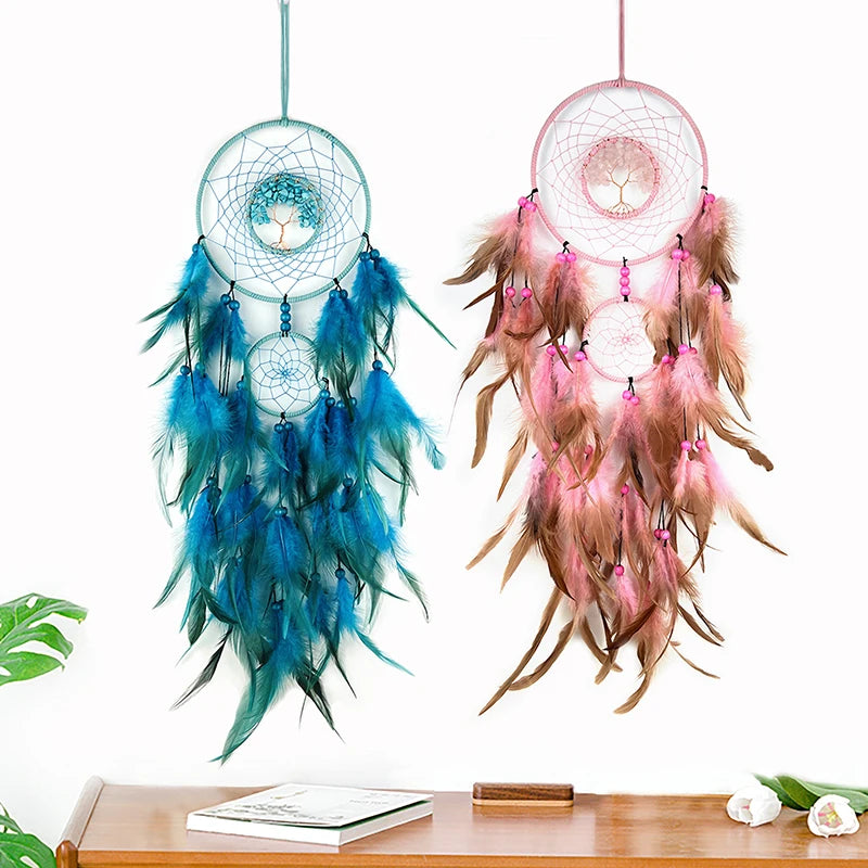 Deux magnifiques attrape-rêves colorés, l'un bleu et l'autre rose, suspendus sur un fond blanc, avec des plumes et des perles qui créent un effet décoratif et apaisant.