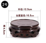 support circulaire bois sculpté artisanal traditionnel marron foncé détails complexes vase plantes décoration maison