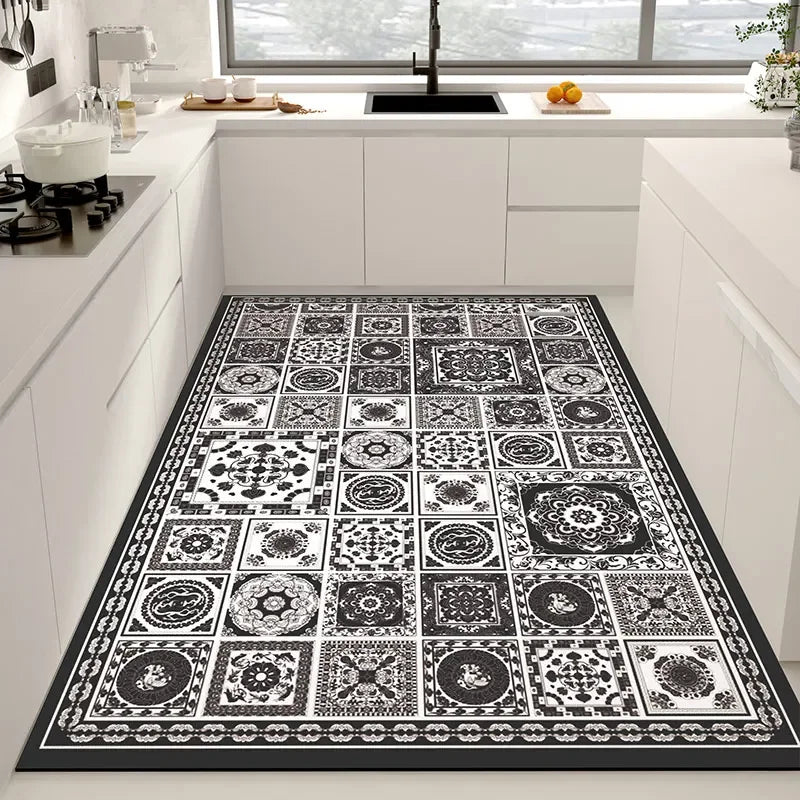 Tapis décoratif aux motifs noirs et blancs, composé de différents carreaux ornementés, offrant un design sophistiqué et élégant à la cuisine.
