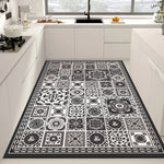 Tapis décoratif aux motifs noirs et blancs, composé de différents carreaux ornementés, offrant un design sophistiqué et élégant à la cuisine.