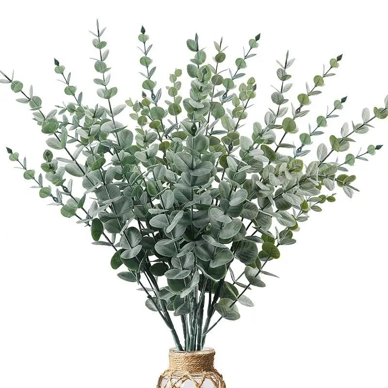 bouquet artificiel feuilles vertes naturel minimaliste ruban blanc vase blanc tapis beige ornement extérieur
