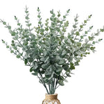 bouquet artificiel feuilles vertes naturel minimaliste ruban blanc vase blanc tapis beige ornement extérieur