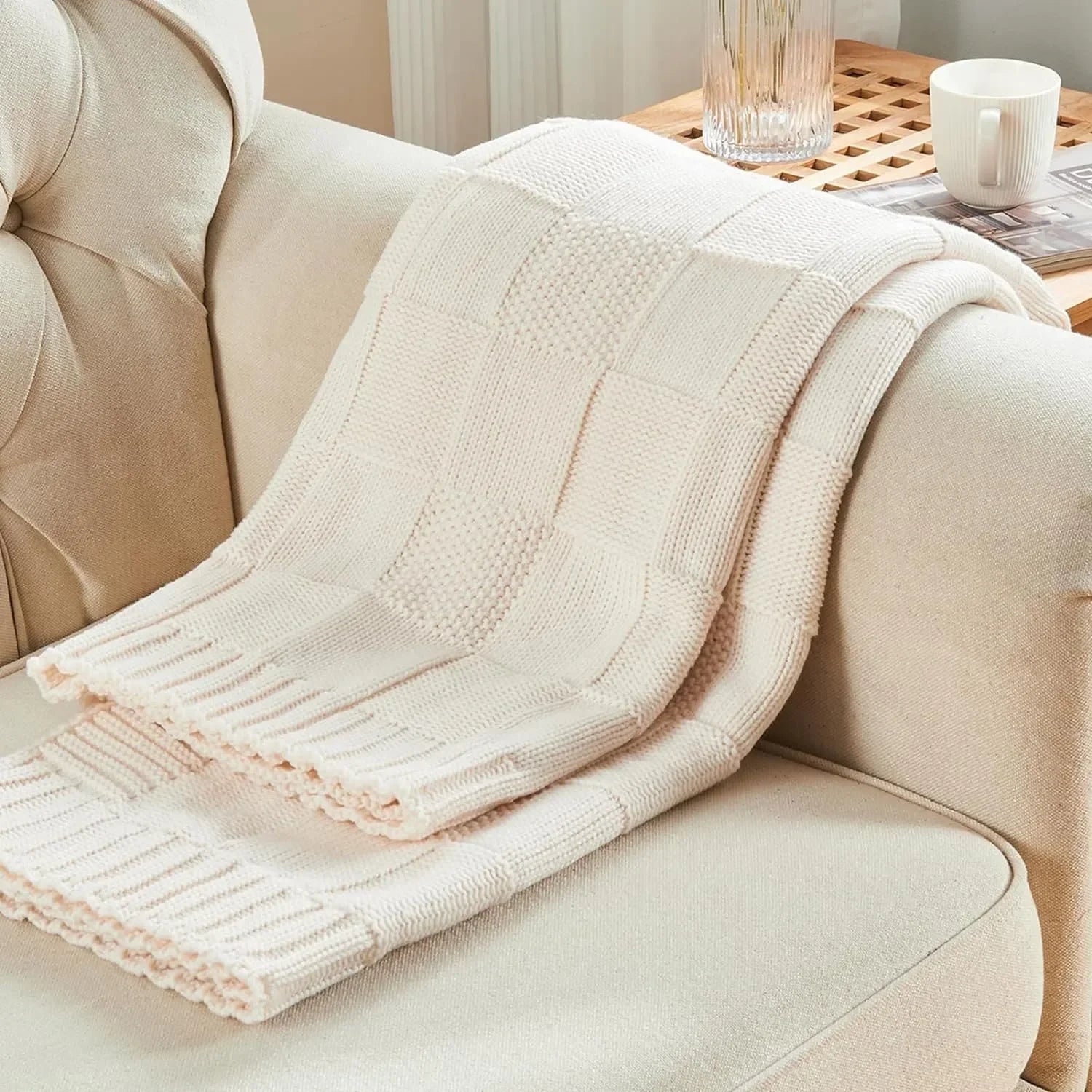 Une couverture en tricot douillette, confort et élégance pour une atmosphère cocooning dans un salon chaleureux.