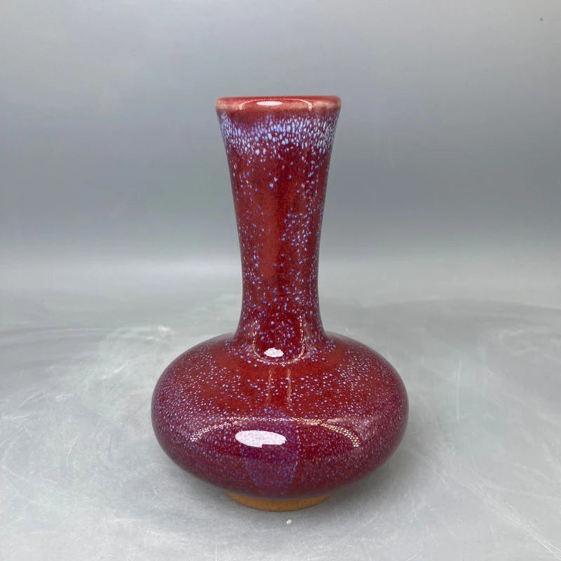 Vase en céramique de couleur rouge bordeaux décoré d'un motif moucheté.