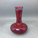 Vase en céramique de couleur rouge bordeaux décoré d'un motif moucheté.
