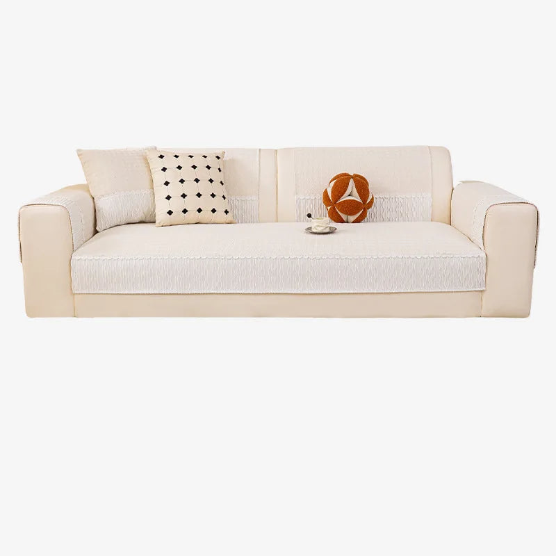 Un canapé moelleux beige avec des coussins décoratifs et une décoration ethnique posée sur l'assise.