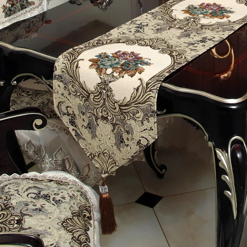 Cette élégante table de salle à manger est recouverte d'un beau chemin de table décoré de motifs floraux et de délicates arabesques, conférant à l'ensemble une atmosphère chaleureuse et raffinée.