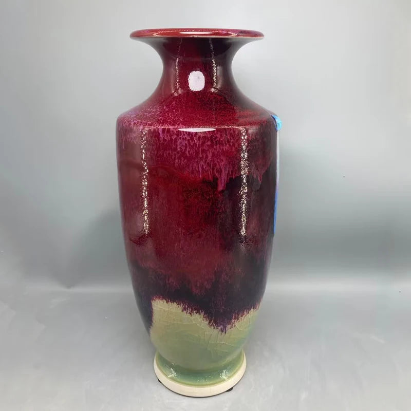 Vase en céramique de forme élancée, orné de nuances de rouge, vert et blanc, créant un effet décoratif et élégant.