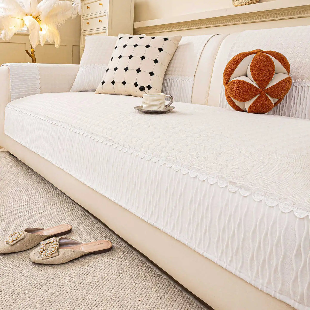 Ce salon accueillant présente un canapé blanc moelleux, des oreillers décoratifs et des accessoires qui créent une atmosphère confortable et élégante.