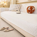 Ce salon accueillant présente un canapé blanc moelleux, des oreillers décoratifs et des accessoires qui créent une atmosphère confortable et élégante.