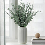 vase blanc moderne fleurs artificielles feuilles vertes décoration table intérieure