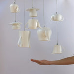 Lampe suspendue céramique grise au-dessus d'une table de cuisine avec décoration contemporaine