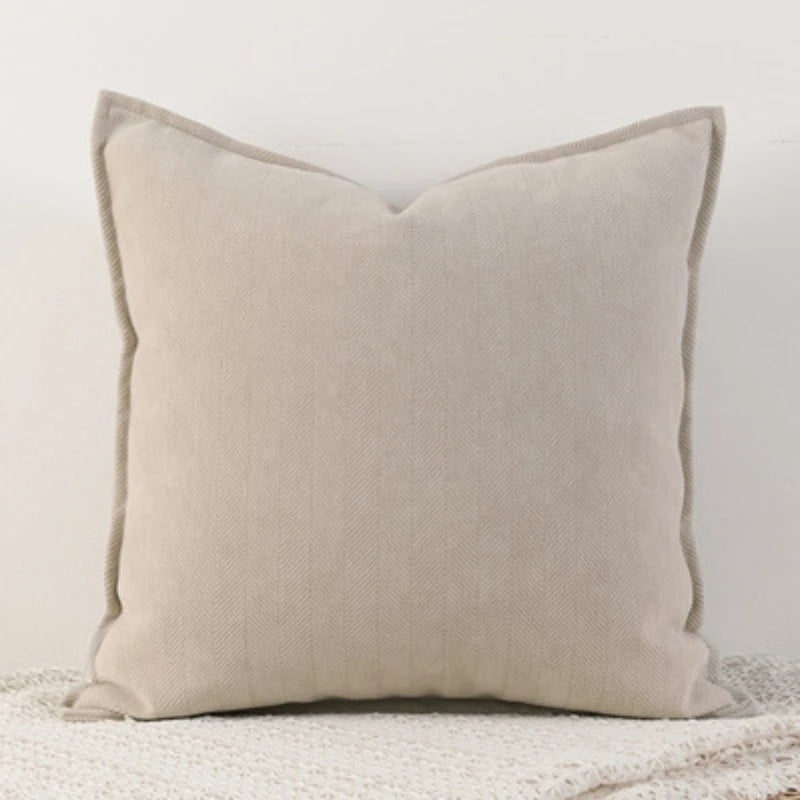 Coussin gris clair en tissu doux et texturé, idéal pour une décoration contemporaine.
