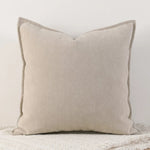 Coussin gris clair en tissu doux et texturé, idéal pour une décoration contemporaine.