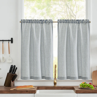 Rideaux de cuisine à rayures bleues et blanches, suspendus devant une fenêtre lumineuse. Idéal pour ajouter une touche élégante et pratique à votre espace culinaire. Conception moderne qui s'adapte parfaitement aux intérieurs contemporains. Complété par un plan de travail décoré avec des ustensiles et des fruits.