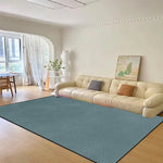 Un bel intérieur avec un grand canapé beige, une fenêtre donnant sur l'extérieur et un tapis vert sur le sol, créant une atmosphère chaleureuse et élégante.