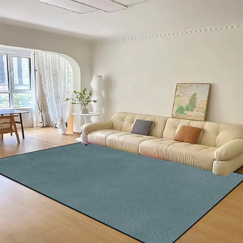 Un bel intérieur avec un grand canapé beige, une fenêtre donnant sur l'extérieur et un tapis vert sur le sol, créant une atmosphère chaleureuse et élégante.